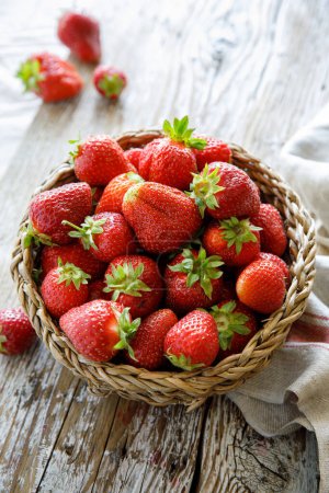 Photo for Fresh ripe strawberries in the basket on a wooden table - Royalty Free Image