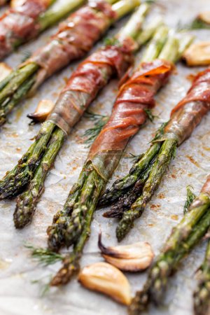 Photo for Close-up view of grilled green asparagus wrapped in long-matured ham - Royalty Free Image