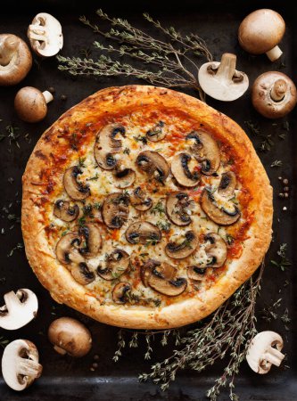 Téléchargez les photos : Pizza aux champignons avec l'ajout de champignons bruns tranchés, champignons et herbes sur fond noir, vue de dessus - en image libre de droit