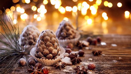 Téléchargez les photos : Cônes de pin chocolat saupoudré de sucre en poudre, vue rapprochée. Idée pour le dessert de Noël - en image libre de droit