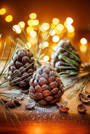 Téléchargez les photos : Cônes de pin chocolat saupoudrés de sucre en poudre, se concentrer sur le cône à l'intérieur. Dessert délicieux de Noël - en image libre de droit
