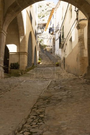 Photo for Beautiful architectural corner of Castellote, Teruel, Maestrazgo, Aragon, Spain, view of some old stairs from a semicircular arch, hdr photo - Royalty Free Image