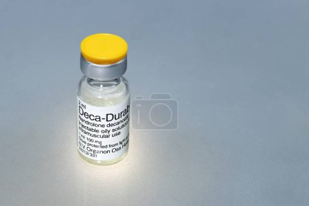 Photo for Spain, Madrid, 01-13-2022, A vial of liquid substance to be injected, an anabolic steroid called nandrolone decanoate on a gray background - Royalty Free Image