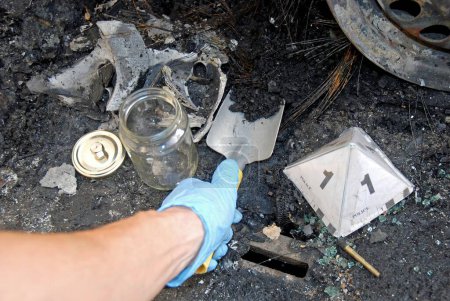 La Policía Científica, CSI, recogiendo muestras de restos carbonizados quemados en un incendio provocado por vehículos