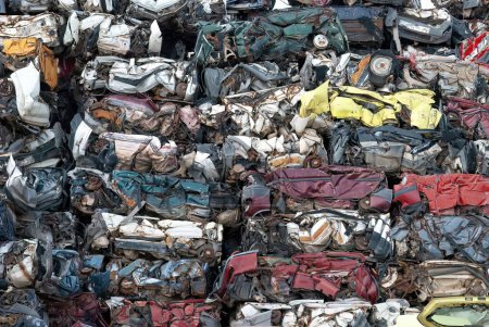 Wallpaper of a multitude of cars stacked and crushed for vehicle recycling, concept of clean point and care for the environment