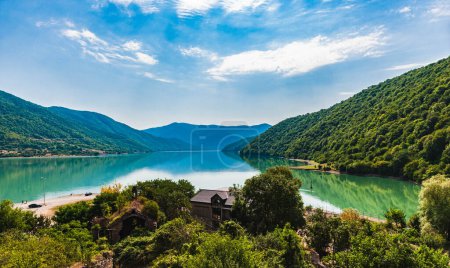 Photo for View of the Zhinvali Reservoir, a picturesque artificial reservoir in Georgia.Blue sky with white clouds.The reservoir is armed with mountains.Mountains are reflected in the water.Copy space. - Royalty Free Image