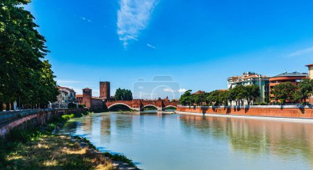 Italy.Verona.View of the Adige river.The Scaliger Bridge and Castelvecchio Castle are visible in the distance.Blue sky with white clouds.Copy space.