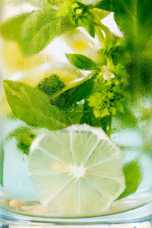 Foto de Copa de limonada con hojas de albahaca y limones - Imagen libre de derechos