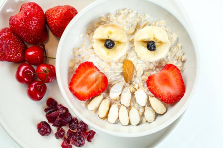 Photo for Kids breakfast porridge with fruits and nuts - Royalty Free Image