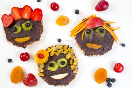 Photo for Funny faces toasts with spread chocolate and dates and fruit - Royalty Free Image