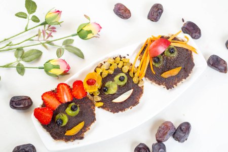 Foto de Caras divertidas tostadas con chocolate extendido y dátiles y frutas - Imagen libre de derechos