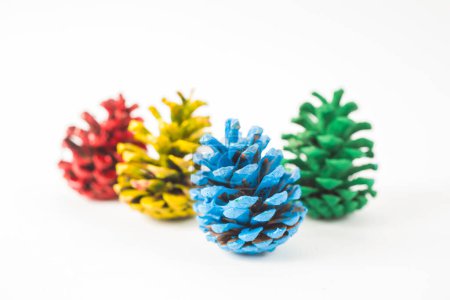 Foto de Conjunto amarillo, verde, azul y rojo de conos de pino aislados sobre fondo blanco - Imagen libre de derechos
