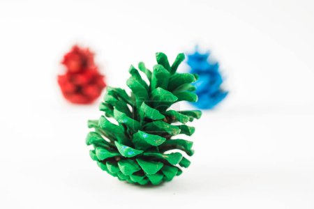 Foto de Conjunto amarillo, verde, azul y rojo de conos de pino aislados sobre fondo blanco - Imagen libre de derechos
