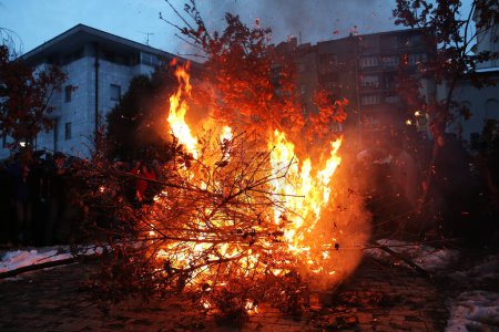 Foto de BELGRADO - 6 DE ENERO: La gente ve una quema ceremonial de ramas de roble seco - el símbolo del tronco de Yule para la víspera de Navidad ortodoxa frente a la iglesia de San Sava el 6 de enero de 2016 en Belgrado, Serbia. - Imagen libre de derechos