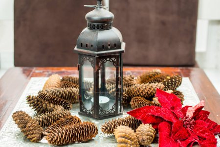 Photo for Christmas arrangement of red flower, vintage candlestick and pine cones - Royalty Free Image