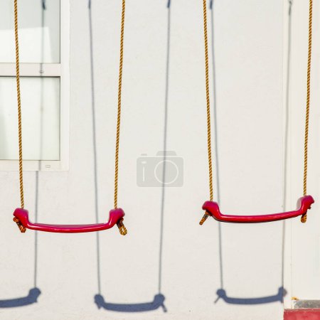 Photo for Set of red swings on modern kids playground - Royalty Free Image