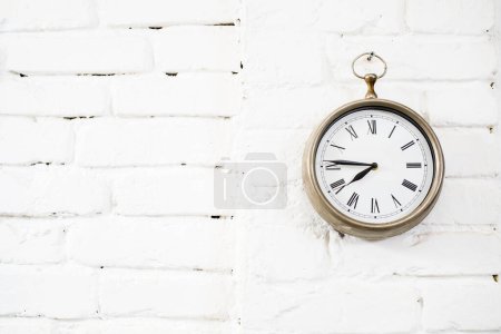 Foto de Reloj de bolsillo grande. reloj de metal en la pared blanca - Imagen libre de derechos