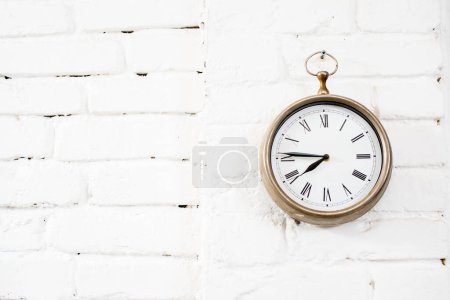 Téléchargez les photos : Grande montre de poche. horloge en métal sur mur blanc - en image libre de droit
