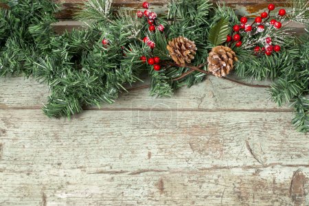 Téléchargez les photos : Fond de Noël avec pin, planches rustiques en bois et baies. Thème des vacances d'hiver. Bonne année. Espace pour le texte. - en image libre de droit