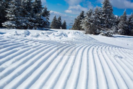 Téléchargez les photos : Lignes de neige fabriquées à partir d'une machine à neige sur une piste de ski - en image libre de droit