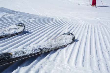 Photo for Snow lines made from a snow machine on a ski slope with skis - Royalty Free Image