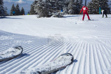 Photo for Snow lines made from a snow machine on a ski slope with skis - Royalty Free Image
