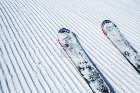 Téléchargez les photos : Lignes de neige fabriquées à partir d'une machine à neige sur une piste de ski avec skis - en image libre de droit