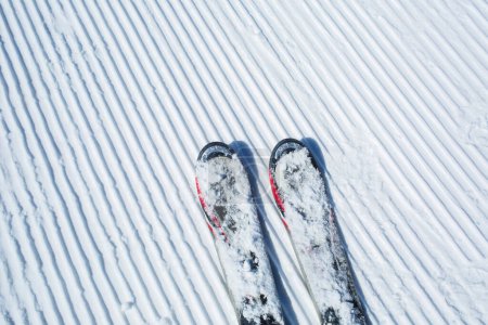 Téléchargez les photos : Lignes de neige fabriquées à partir d'une machine à neige sur une piste de ski avec skis - en image libre de droit