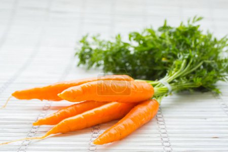 Photo for Freshly harvested bunch of carrots on a white background - Royalty Free Image