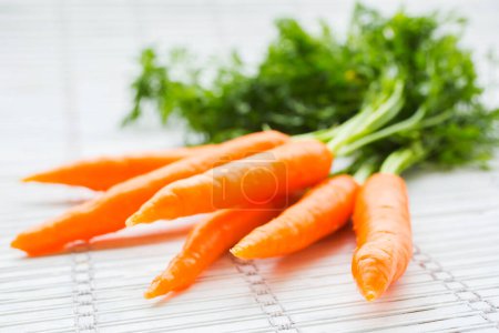 Photo for Freshly harvested bunch of carrots on a white background - Royalty Free Image