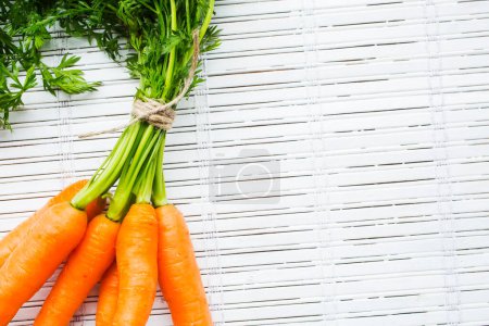 Téléchargez les photos : Bouquet fraîchement récolté de carottes sur fond blanc - en image libre de droit