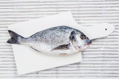 Photo for Fresh sea bream on a cutting board on the isolation of a white background - Royalty Free Image