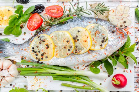 Photo for Fresh raw gilthead fishes with lemon, herbs, salt on a wooden board , white wooden background. Healthy food concept. Food frame.Fish bream - Royalty Free Image