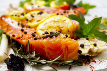 Téléchargez les photos : Filet de saumon cru, épices et légumes sur une assiette blanche. Vue du dessus
. - en image libre de droit