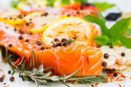 Téléchargez les photos : Filet de saumon cru, épices et légumes sur une assiette blanche. Vue du dessus
. - en image libre de droit