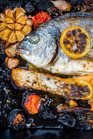 Téléchargez les photos : Dorade et saumon dans une poêle noire aux légumes et épices - en image libre de droit