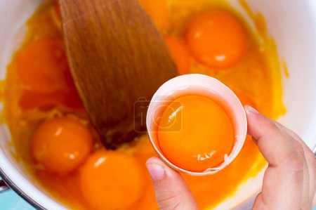 Téléchargez les photos : Gros plan d'une main craquant un œuf dans un bol - en image libre de droit