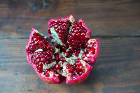 Photo for Pomegranate isolated on a wooden background - Royalty Free Image