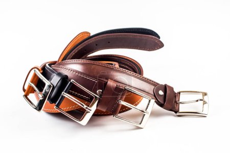 Different leather belts on white background