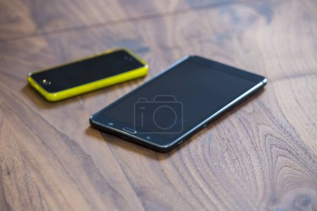 Foto de Smartphones con pantalla negra sobre fondo de madera. - Imagen libre de derechos
