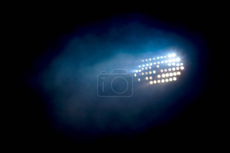 Torre de luz encendida en un estadio durante la noche
.