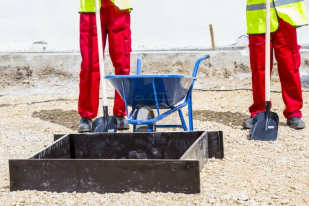 Photo for Workers with wheelbarrow on construction site - Royalty Free Image