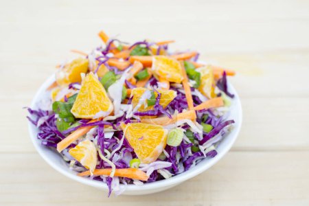 Téléchargez les photos : Salade fraîche de légumes d'automne - chou violet et vert, carottes, oignons verts. Riche déjeuner végétarien en vitamines - en image libre de droit