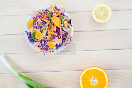 Foto de La ensalada fresca hortalizas otoñales - la col púrpura y verde, la zanahoria, la cebolla verde. Almuerzo vegetariano rico en vitaminas - Imagen libre de derechos