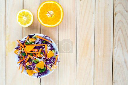 Téléchargez les photos : Salade bio fraîche dans un bol blanc sur fond de bois - en image libre de droit