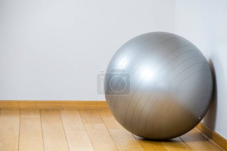 Foto de Pelota gris para fitness sobre fondo de madera - Imagen libre de derechos