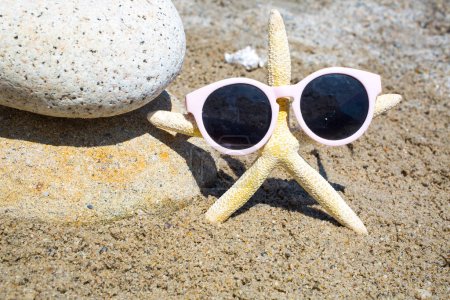 Photo for Funny starfish with sunglass on the sandy beach at sea background - Royalty Free Image