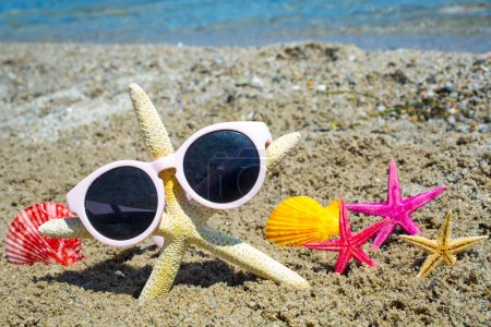 Foto de Funny estrella de mar con gafas de sol en la playa de arena en el fondo del mar - Imagen libre de derechos