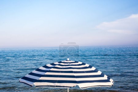 Foto de Sombrilla de playa en un día soleado, mar de fondo - Imagen libre de derechos