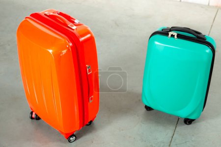 Photo for Orange and green travel bags on white brick background - Royalty Free Image